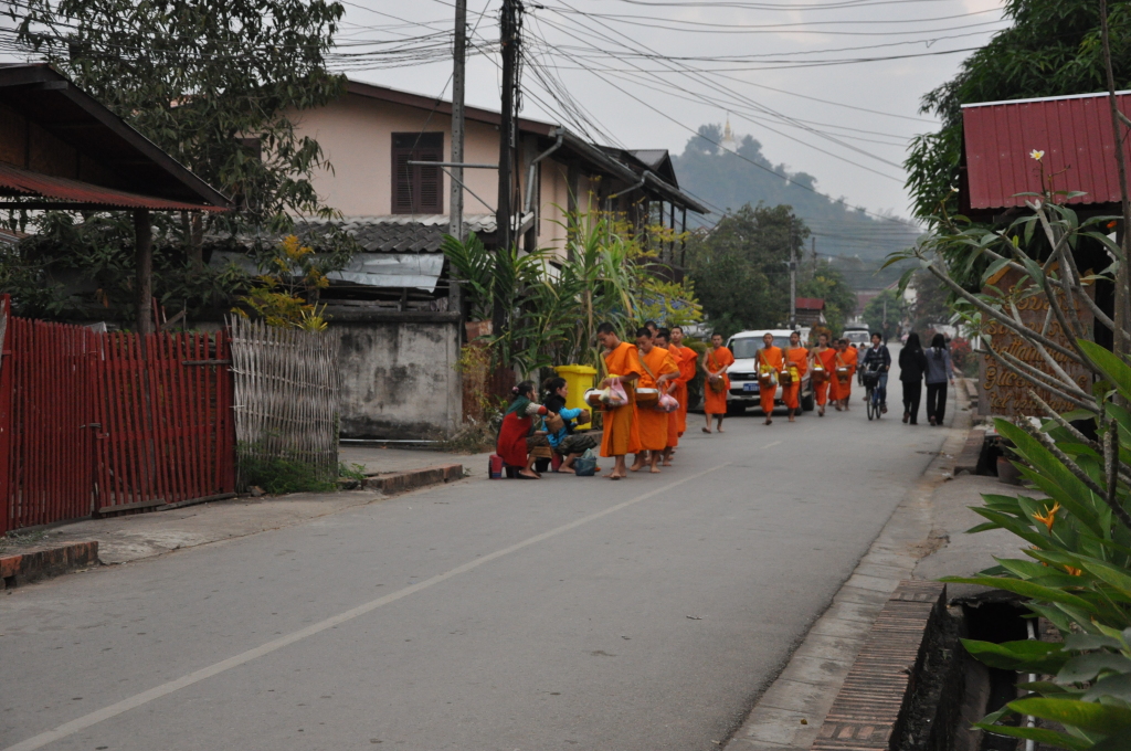 a group of people in orange robes walking down a street